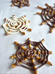 three different types of chocolate and pretzels on a sheet of paper with brown and white icing