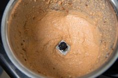 a food processor filled with brown batter on top of a stove burner and silver lid