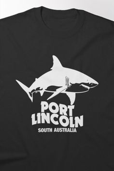 a black t - shirt with a white shark on it's chest and the words port lincoln south australia