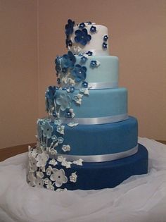 a three tiered cake with blue and white flowers