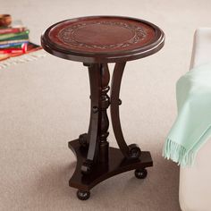 a small wooden table sitting on top of a carpeted floor next to a white couch