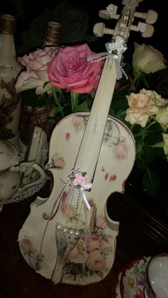 a violin is sitting on a table next to flowers