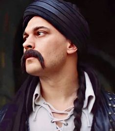 a man with long braids and a moustache