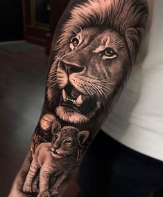 a man with a lion and cub tattoo on his arm