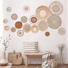 a white room with lots of baskets on the wall and a bench in front of it