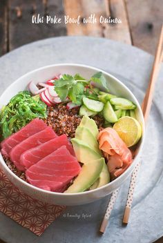 a bowl filled with meat and vegetables on top of a table next to chopsticks