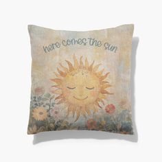 a pillow with the words here comes the sun on it