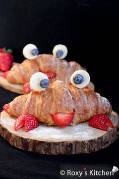 two croissants with googly eyes and strawberries are on top of each other