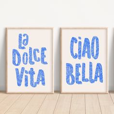 two framed posters with the words la douce vita and cia bella in blue ink