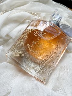 a bottle of perfume sitting on top of a white cloth