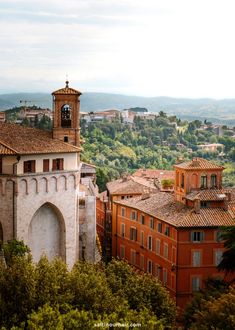 an old building with a clock tower in the middle of it's rooftops