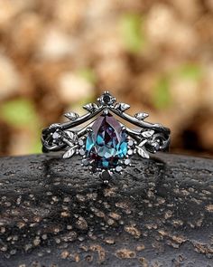 a ring with a blue topazte surrounded by silver filigrees and leaves