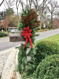 a mailbox decorated with evergreen and red bow