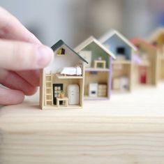 a person holding a miniature house in their hand