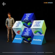 a man standing in front of three cubes with the words deloitte on them