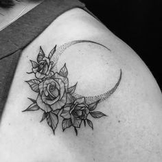 a black and white photo of a woman's shoulder with roses on the moon