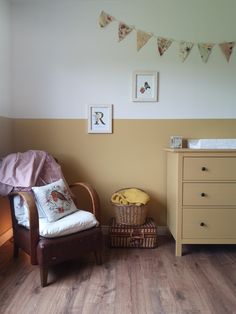 a baby's room with a chair and dresser