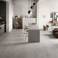 an open kitchen and dining area with white brick walls, flooring and counter tops