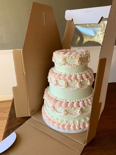 a three tiered cake in a cardboard box