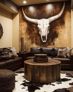 a living room with leather couches and a cow skull on the wall behind it