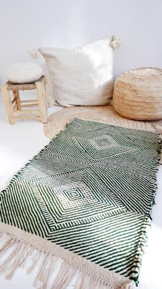 a green and white rug sitting on top of a floor next to a wooden chair