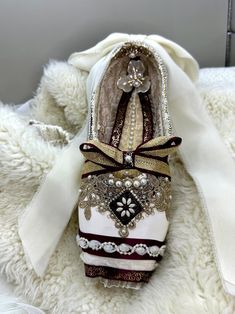 Elevate your holiday décor with our stunning handmade decorated pointe shoe! This exquisite ballet piece features a rich burgundy and gold color scheme, adorned with festive trim that captures the spirit of the season. Perfect for ballet lovers and collectors alike, this unique decoration adds a touch of elegance to any space. Each shoe is meticulously crafted, making it a one-of-a-kind ornament to enhance your festivities. Celebrate the beauty of ballet and make your holidays unforgettable with this beautiful burgundy and gold pointe shoe! Each shoe is crafted by hand and designed to capture and commemorate a special moment. The pictured shoe is the currently complete and available item that will be shipped to you.  If you would like a custom designed shoe, please see my other listing. ht Gold Pointe Shoes, Irregular Choice Shoes, Custom Costumes, Gold Color Scheme