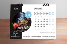 a calendar with the image of a grilling steak on it is displayed in front of a wooden table