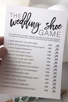 the wedding shoe game is being held up in front of a white sign with black lettering