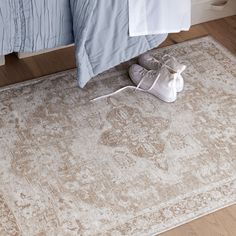 a pair of shoes sitting on top of a rug next to a bed