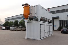 a large white container sitting in front of a building with an orange cone on top