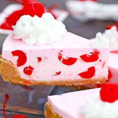 a piece of cheesecake with cherries and whipped cream on top is being held by a fork