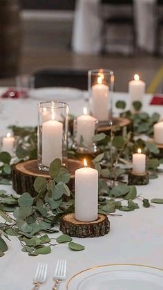 the table is set with candles and greenery