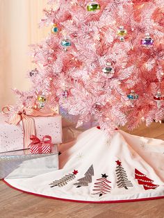 a pink christmas tree with presents under it