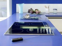 a blue kitchen counter top with an electric stove and various cooking utensils on it