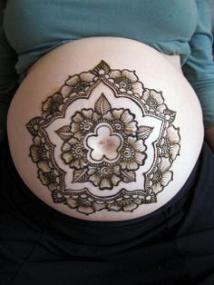 a pregnant woman's belly with hendix on it and an intricate design