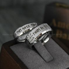 two silver rings with compass symbols on them