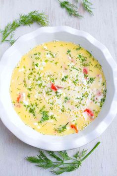 a white bowl filled with soup and garnished with parsley on the side