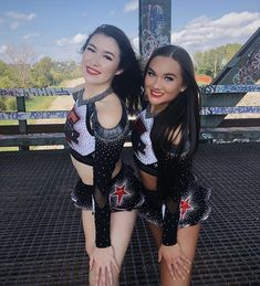 two women in black and white outfits posing for the camera with their arms around each other