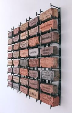 a wall mounted wine bottle rack filled with lots of bottles and corks on it