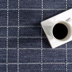 a cup of coffee sitting on top of a white saucer next to a napkin