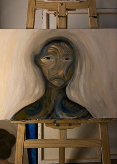 an oil painting of a woman's face on a canvas in front of a easel