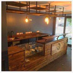 an empty restaurant with wooden counter tops and lights hanging from the rafters above it