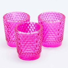 three pink glass cups sitting next to each other