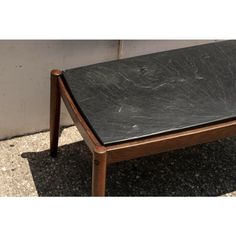 a black marble top coffee table with wooden legs