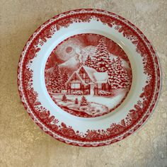 a red and white plate with a house on it