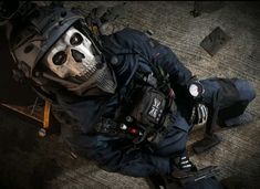 a man in a skeleton mask and overalls laying on the ground next to some tools