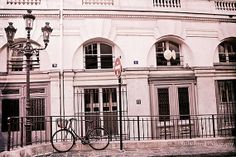 a bicycle parked in front of a building with windows and balconies on it