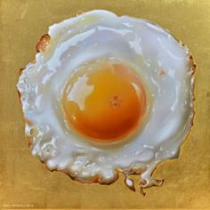 an egg is shown in the middle of a golden plate with white and brown paint