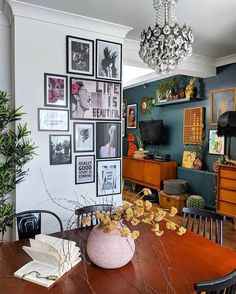 a dining room table with pictures on the wall