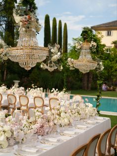 an outdoor wedding reception with chandeliers and flowers